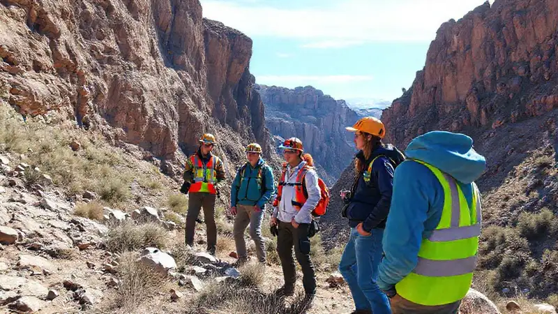 Estudiantes de geología explorando rocas y acantilados
