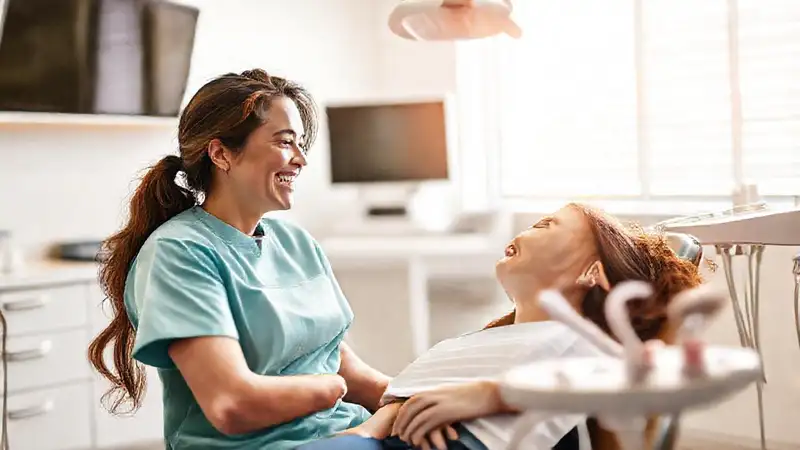 Dentista cuidando con sonrisa en ambiente cómodo
