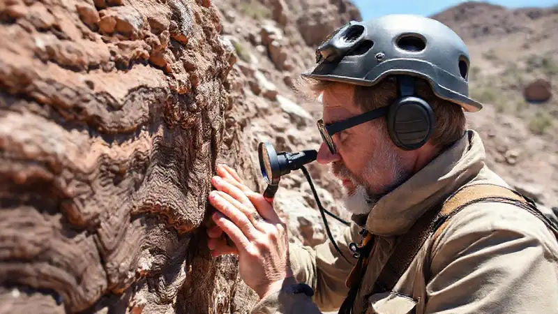 Geólogo examina rocas en terreno al aire libre