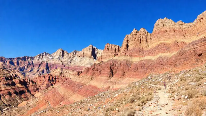 Paisaje montañoso con rocas estratificadas y sendero