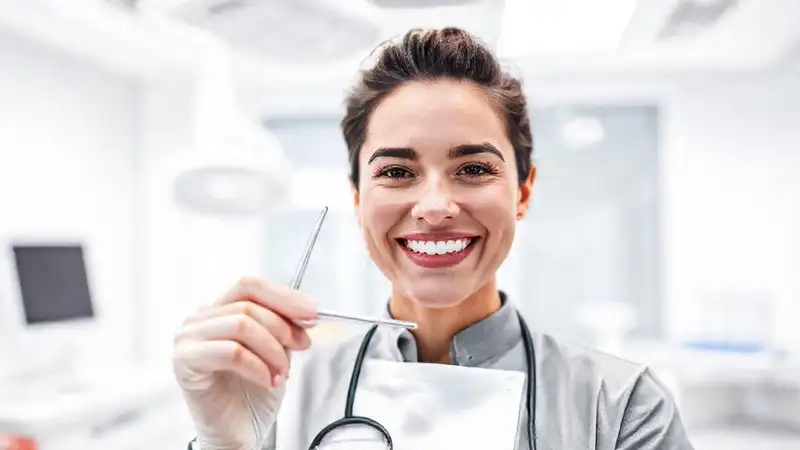 Dentista sonriente con herramientas en clínica moderna