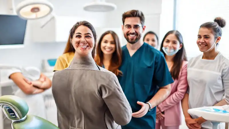 Líder dental con equipo en clínica moderna