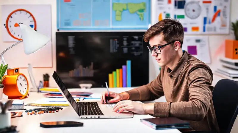 Estudiante concentrado con herramientas digitales y orden