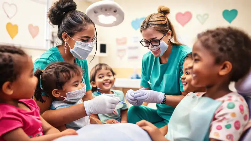 Voluntario dental ayuda niños en clínica vibrante
